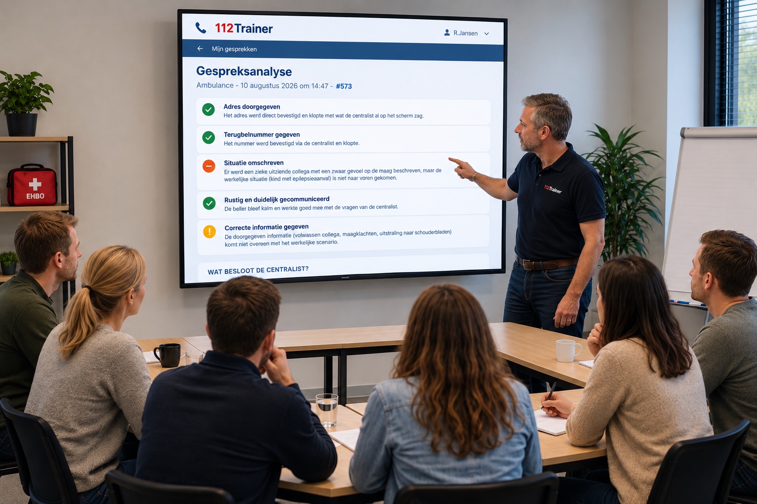 Instructeur bespreekt de gespreksanalyse van een 112-oefengesprek na met een groep cursisten, de feedbackpunten staan op een groot scherm
